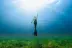 a woman standing in the middle of a grassy field